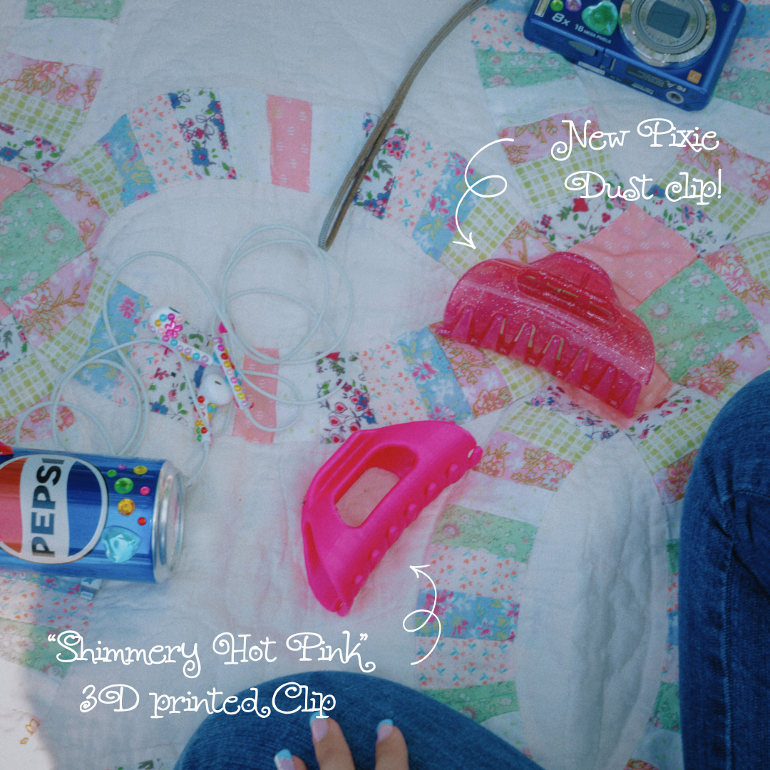 Top view of Pixie Dust flexible claw clip showcasing a shimmery hot pink 3D-printed design on a patchwork quilt